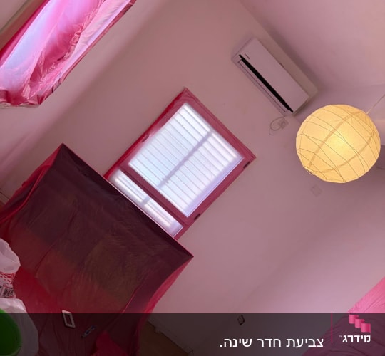 חדר עם קירות צבועים, חלונות מכוסים בניילון, כלי עבודה לצביעה